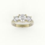 Gouden verlovingsring met rond afgewerkte band en drie diamanten.