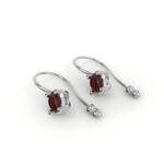 Witgouden oorbellen gezet met robijn, omringd door diamanten.