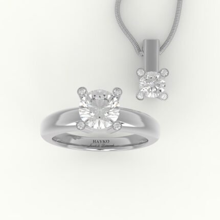 Set van witgouden hanger en solitaire verlovingsring, gezet met centrale diamant en diamanten in de pootjes.