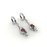 Gouden design oorbellen gezet met diamanten en centrale robijn.