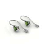 Witgouden oorbellen met smaragd omringd door diamanten.